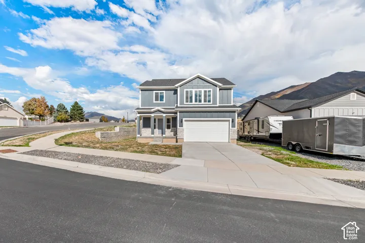 Two-story residence with gray siding, white trim, and a prominent front-facing garage