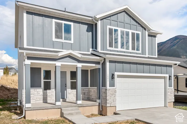 Modern two-story exterior featuring vertical panel siding and stone veneer accents