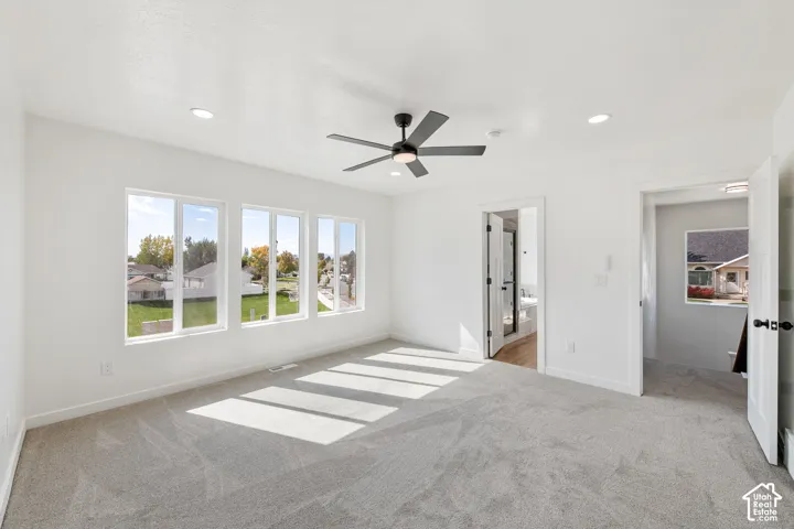 Recessed lighting, ceiling fan with black finish, light gray carpeting, multiple large windows, and white interior doors