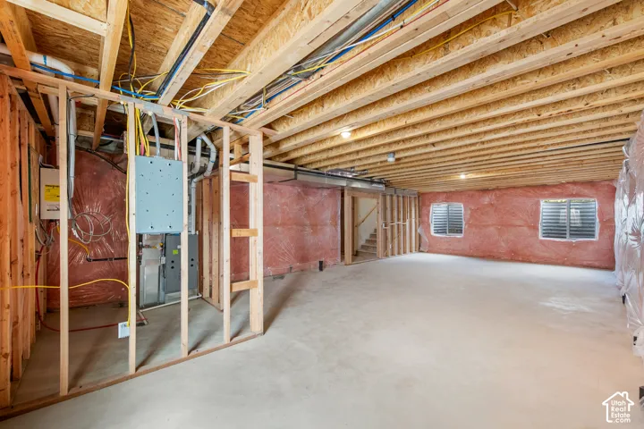 Unfinished basement with concrete flooring and exposed wood framing