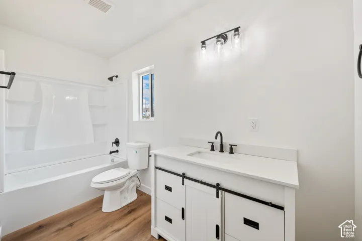 White vanity with barn door style cabinetry, quartz-finish countertop, and black hardware