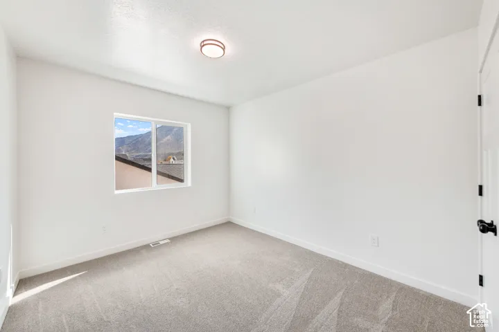 Neutral wall finishes, recessed window, dark carpet flooring, and a flush mount ceiling fixture