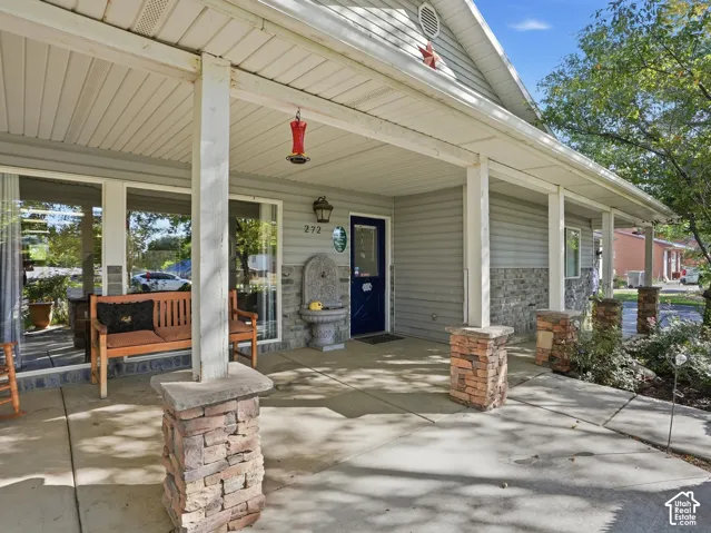 Covered porch with stone-clad columns and a concrete walkway