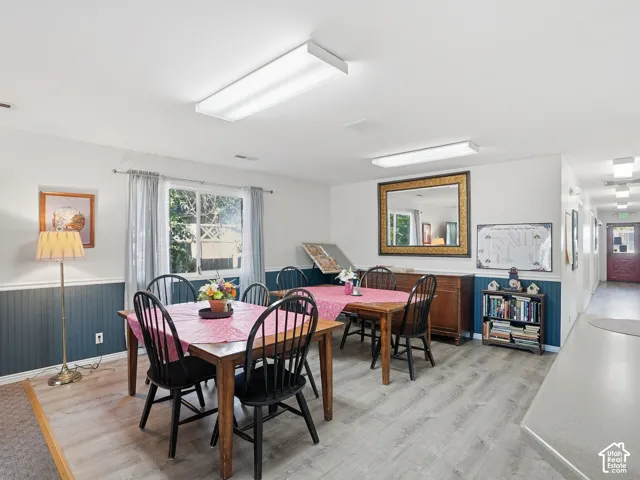 Wood-finish flooring throughout, bright overhead lighting, and wainscoting with a chair rail
