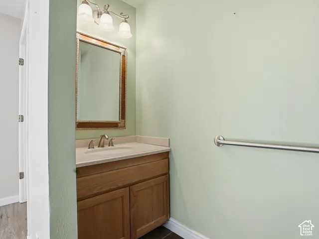 Bathroom vanity with a light wood-finish cabinet, integrated sink, and brushed nickel faucet