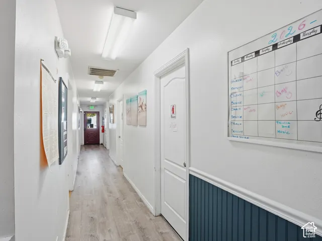 Wood-finish flooring, white walls, white doors, and blue wainscoting