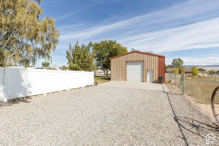 Detached metal-sided structure featuring a roll-up door and a pedestrian entry door