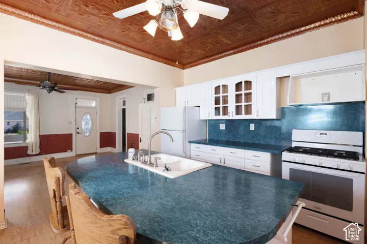 Kitchen featuring white cabinetry, a built-in oven with a gas cooktop, and a double basin sink