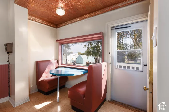 Charming breakfast nook featuring custom booth seating with burgundy upholstery, a small dining table, and large multi-pane windows framing natural light