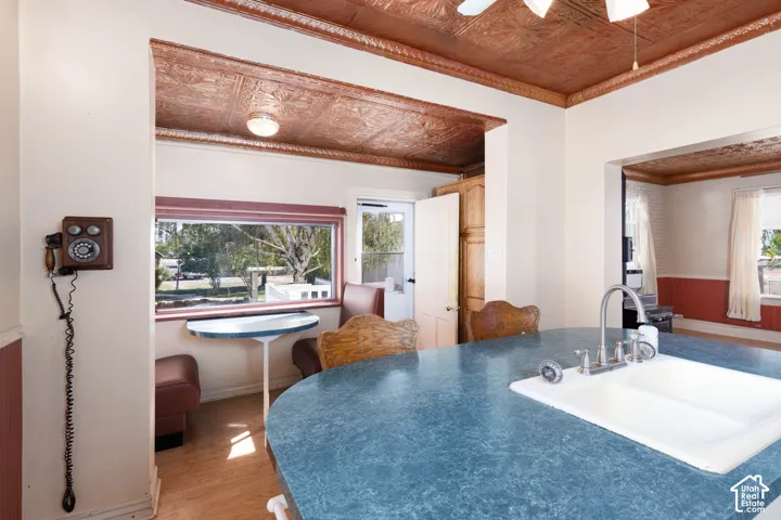 Kitchen area featuring a built-in sink with a gooseneck faucet, a blue countertop, and ornate ceiling panels