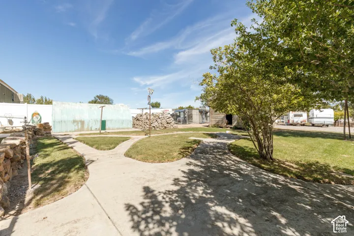 Concrete pathways, rock wall, mature trees, and grassy areas
