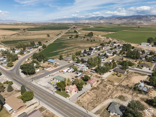 Aerial perspective showcasing a residential area with surrounding agricultural fields and distant mountains
