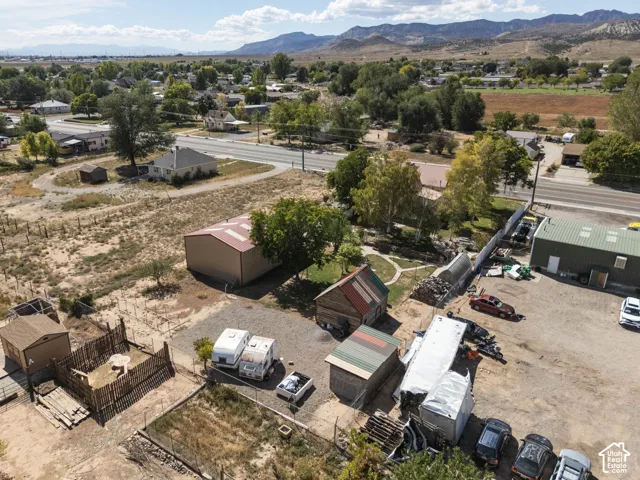 Expansive property with multiple outbuildings, including a large brown metal-roofed structure and a smaller green metal-sided building