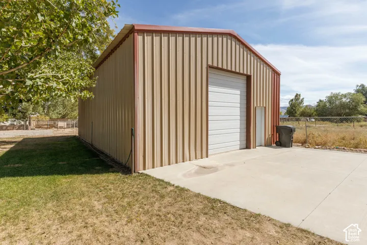 Metal-sided structure featuring a large roll-up garage door and a pedestrian entrance