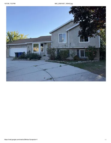 Stucco exterior with multiple window styles, attached garage, and a concrete driveway