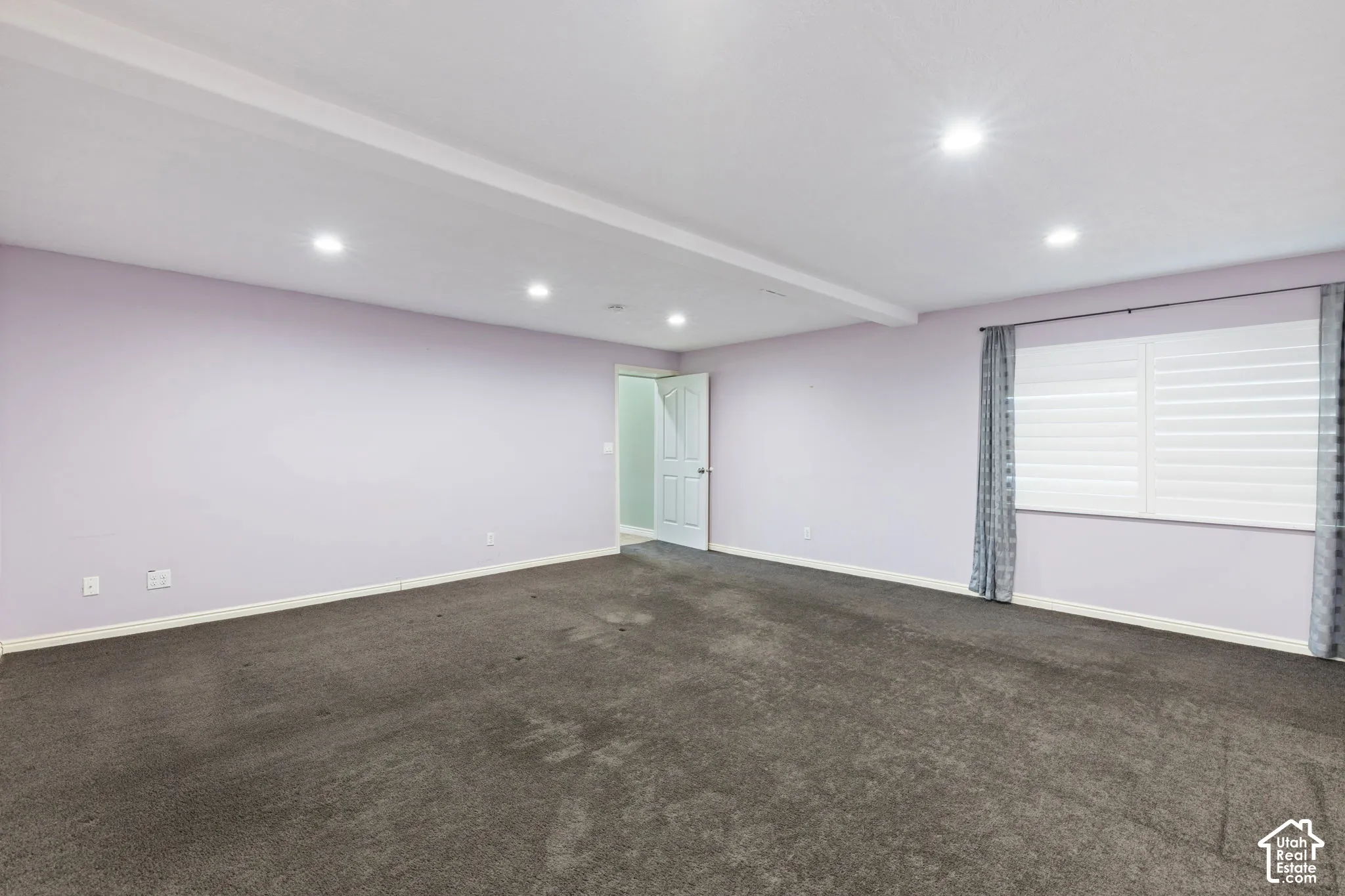 Recessed lighting illuminates the ceiling with exposed beam detailing