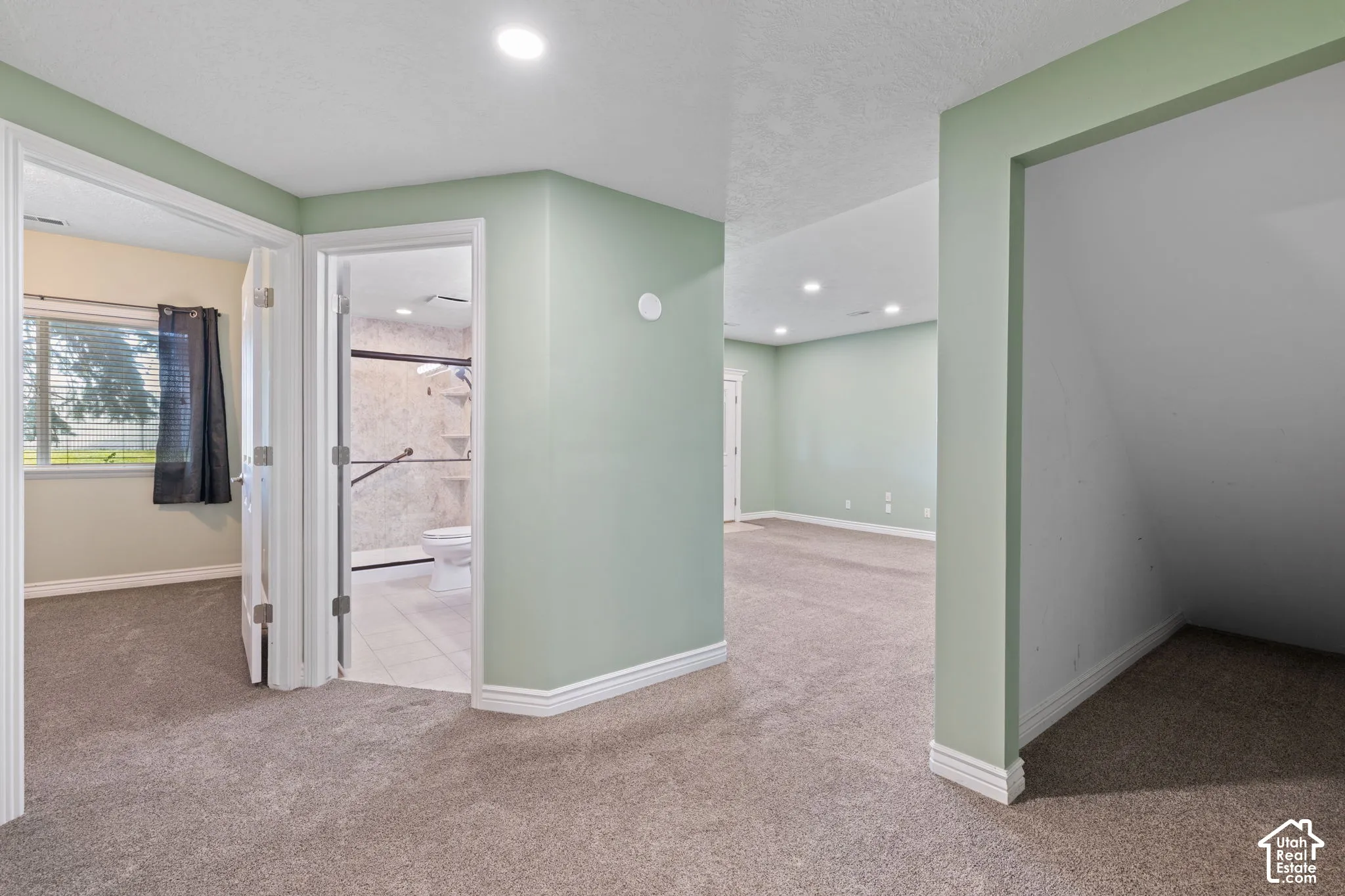 Carpeted flooring throughout, recessed lighting, and a window with blinds