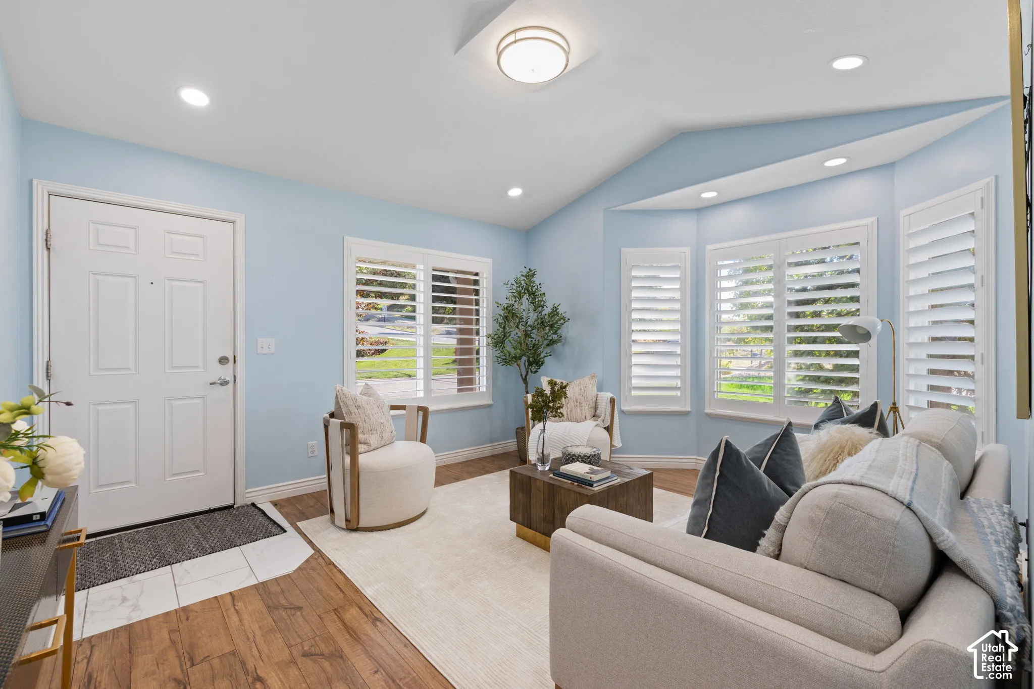 Wood-finish flooring, recessed lighting, and a bay window featuring plantation shutters