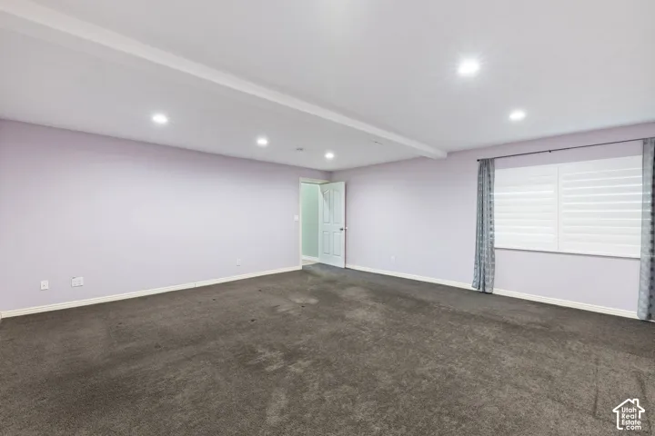 Recessed lighting illuminates the ceiling with exposed beam detailing