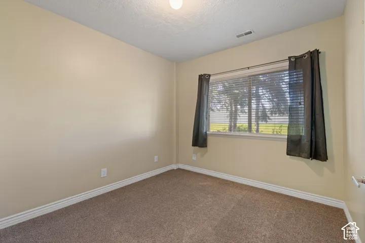 Wall-to-wall carpet flooring, neutral paint palette, and a window with blinds