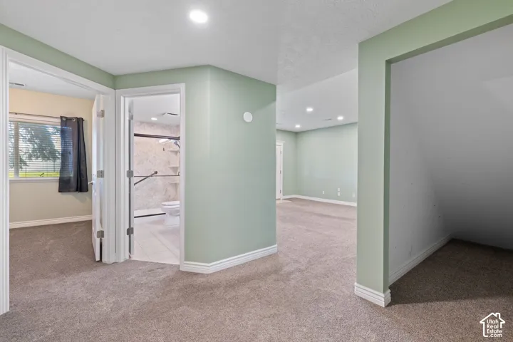 Carpeted flooring throughout, recessed lighting, and a window with blinds