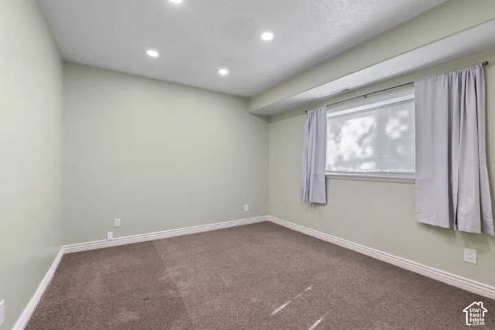 Recessed ceiling lighting, a window with blinds, a carpeted floor, and painted walls