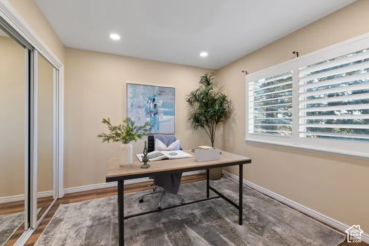 Recessed lighting, wood-finish flooring, and a window with plantation shutters