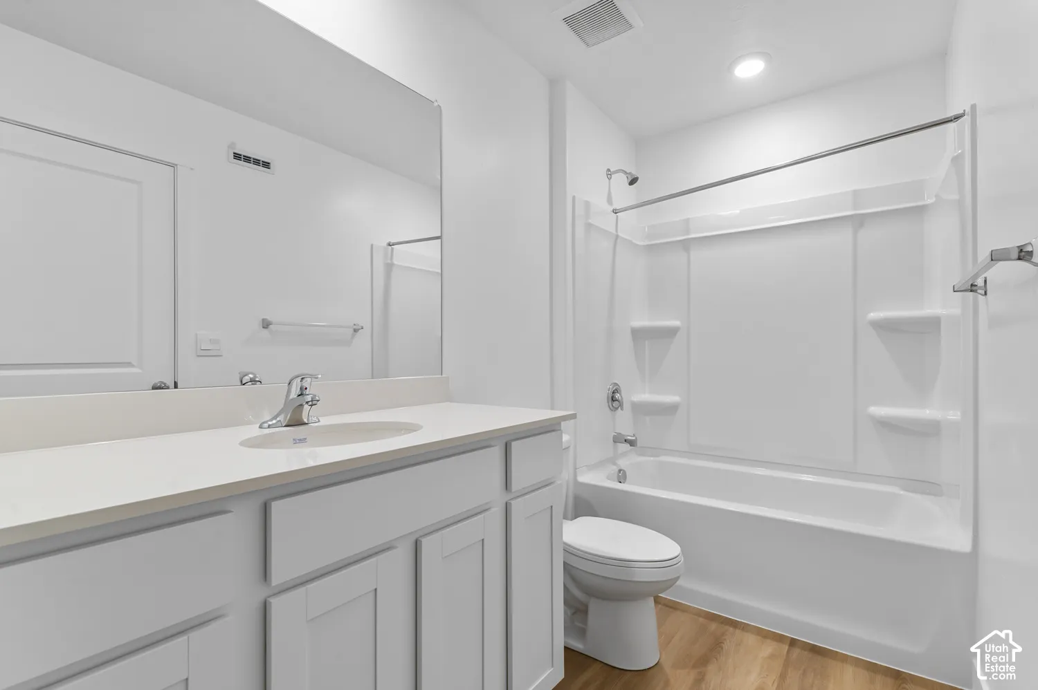 White vanity with an integrated sink, polished chrome faucet, and a large wall-mounted mirror