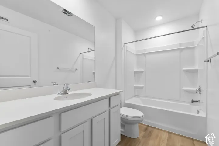 White vanity with integrated sink, chrome faucet, and a large wall-mounted mirror