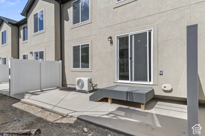 Private patio with concrete surfacing, white vinyl fencing, and direct sliding door access