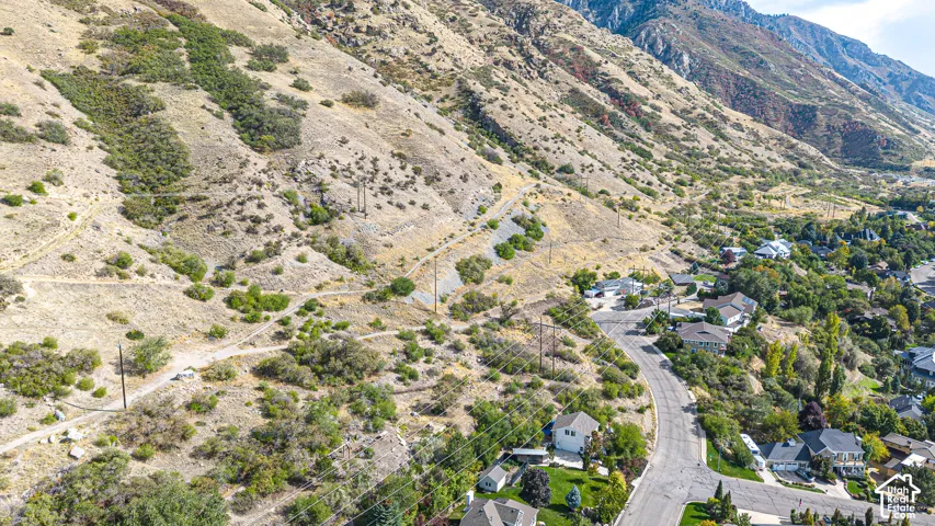 Mountainous terrain surrounding a residential area with established homes and mature trees