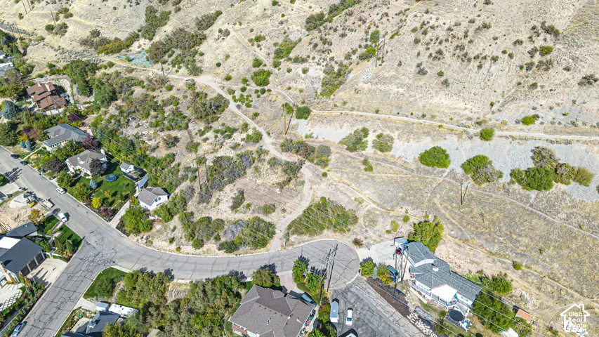 Residential neighborhood with winding roads and cul-de-sacs, surrounded by natural hillsides