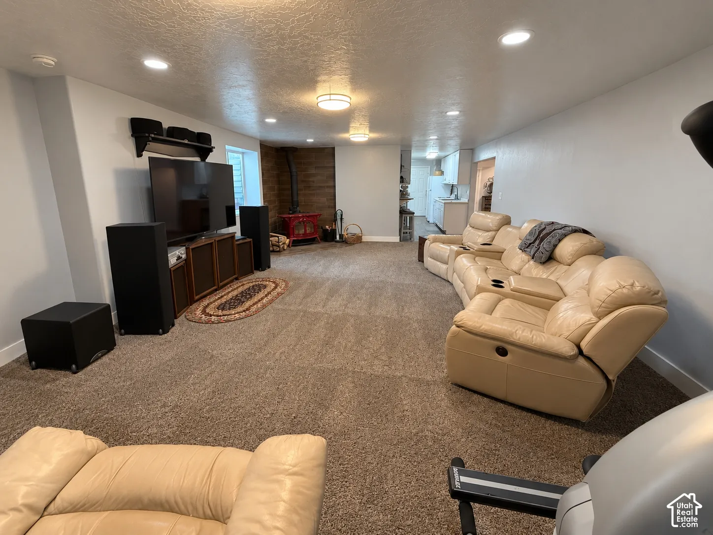 Recessed ceiling lighting, wood-finish accent wall, and a built-in media console