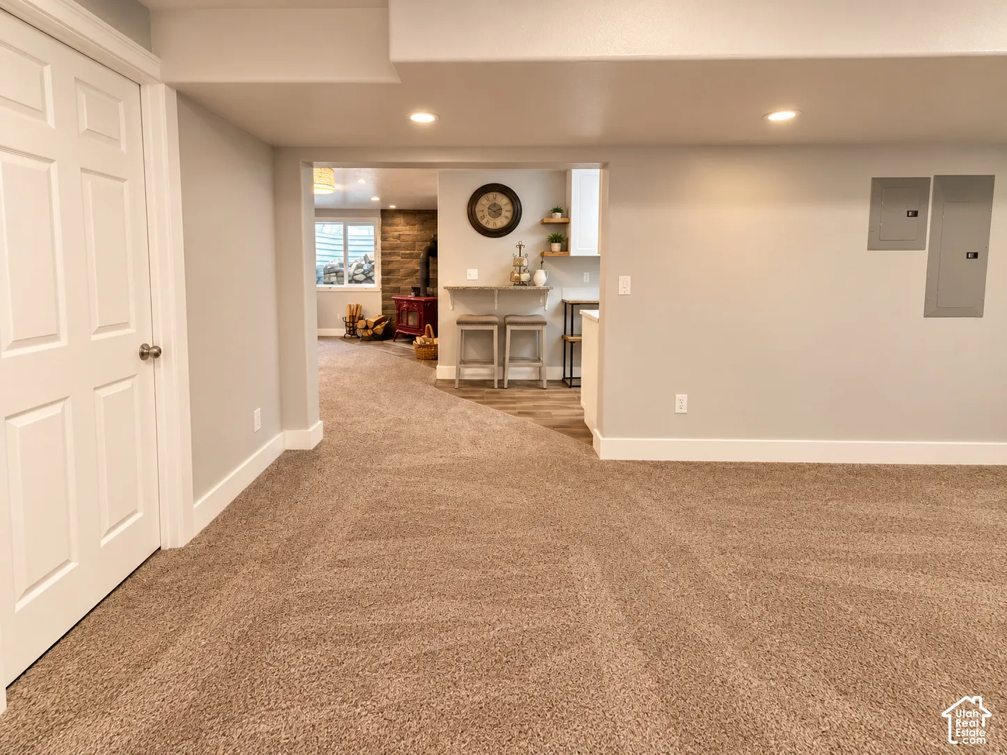 Recessed lighting, wood-finish flooring, white trim, and a white six-panel door