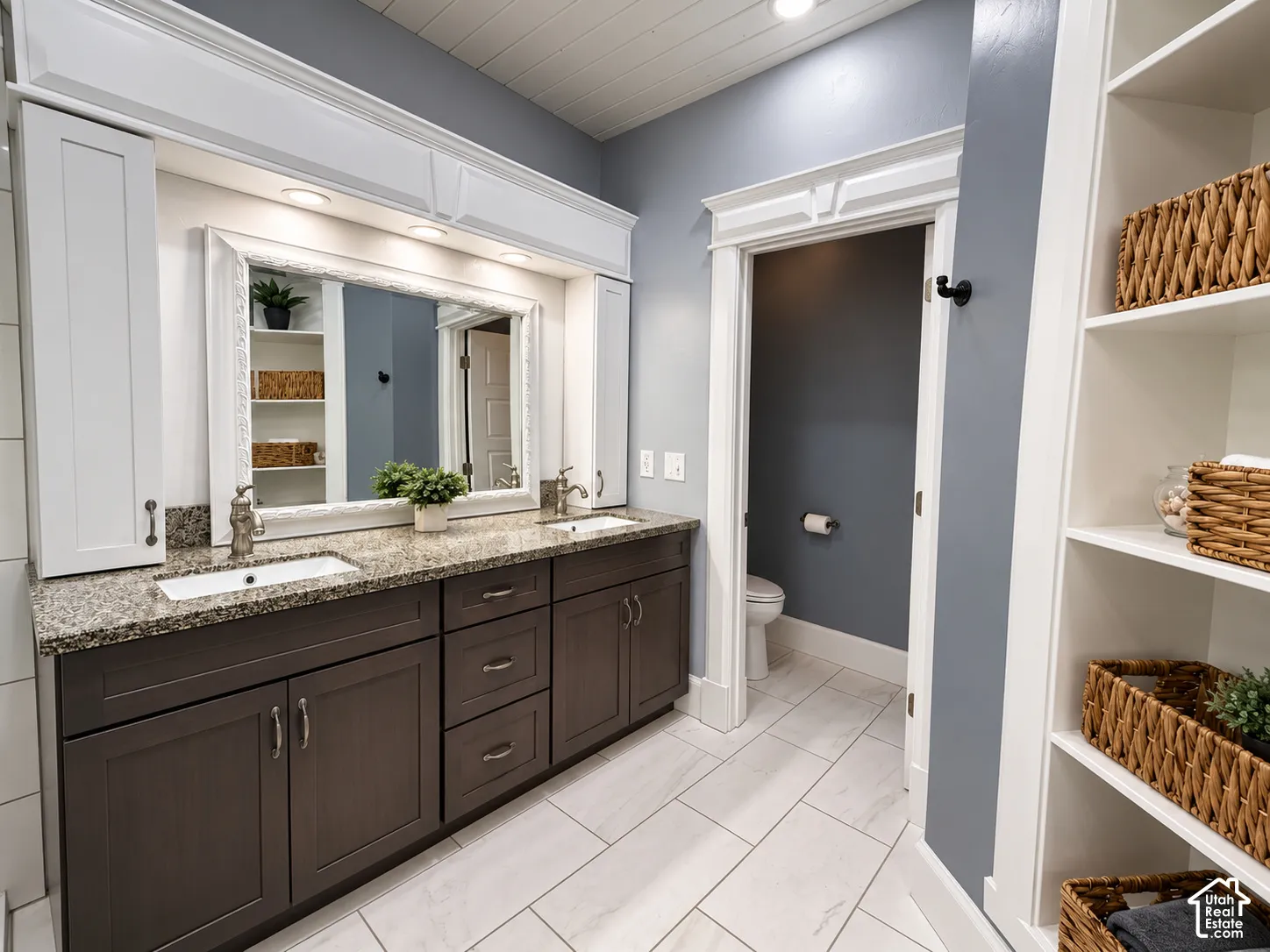 Double vanity with granite countertops, undermount sinks, and dark wood-finish cabinetry