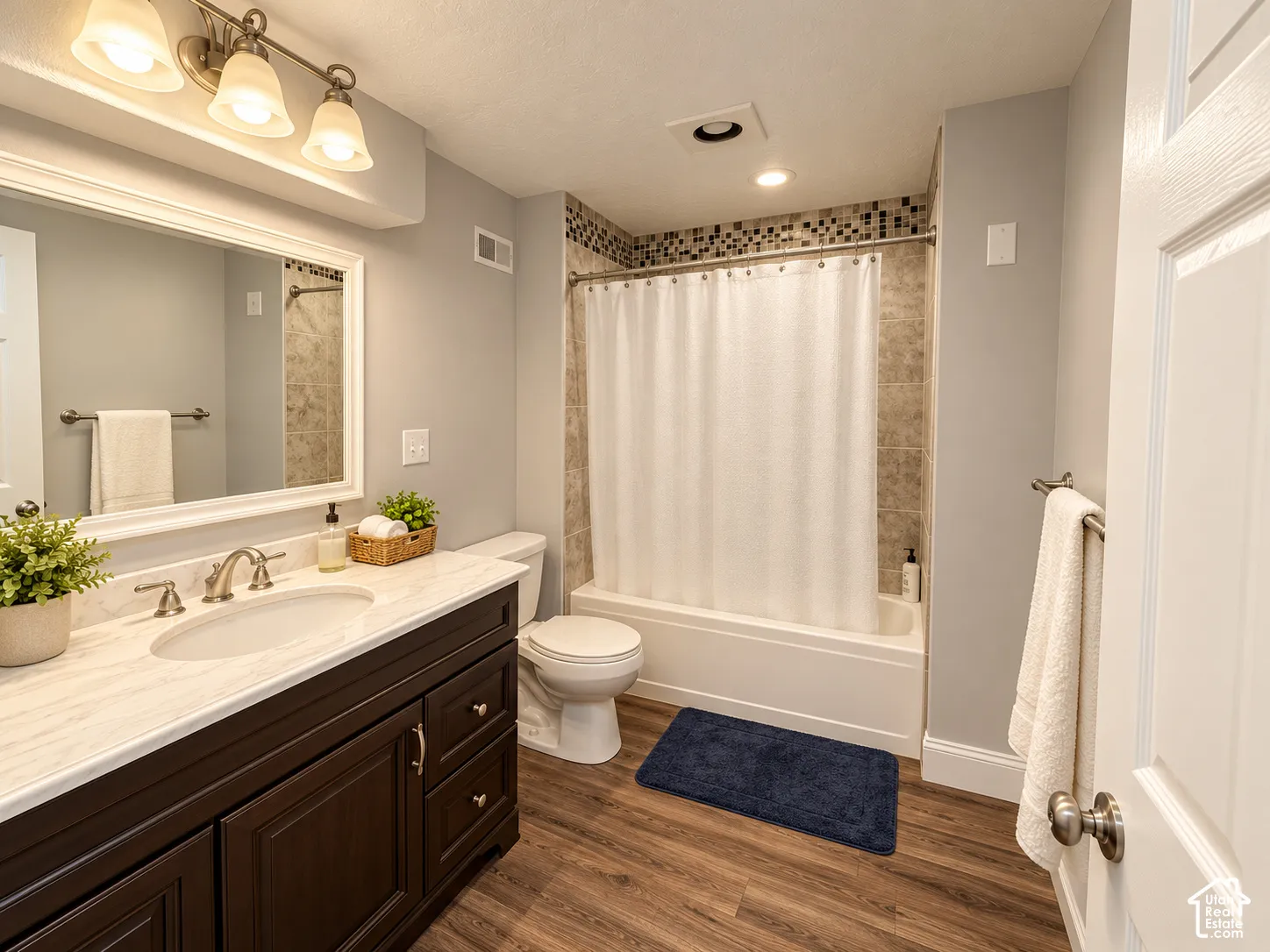 Dark wood-finish vanity with a white countertop and undermount sink