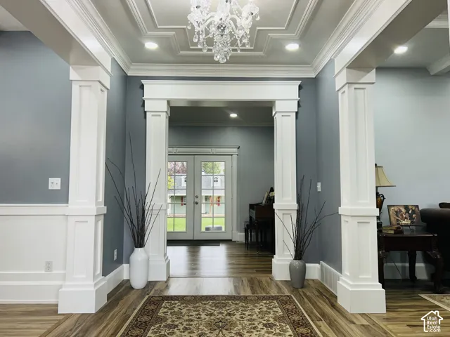 Grand entry with a crystal chandelier, custom tray ceiling with layered molding and statelycraftsman-style columns.