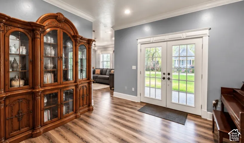 Sitting area with crown molding and French doors opening to the backyard
