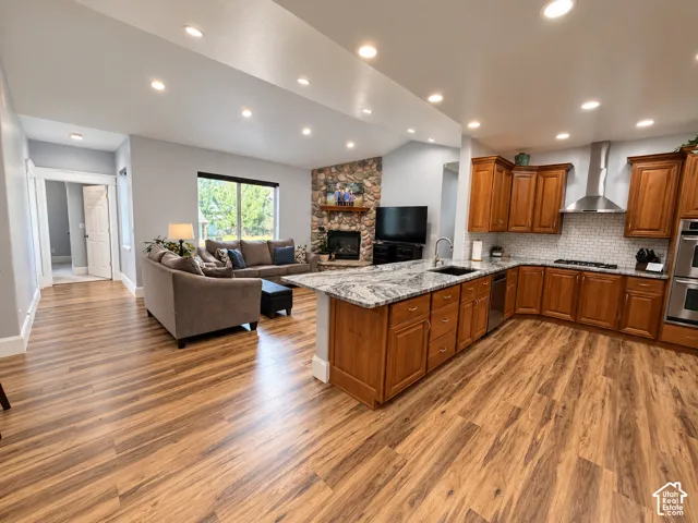 Open-concept kitchen and family room with a vaulted ceiling, river rock fireplace andgranite peninsula, made for gathering.