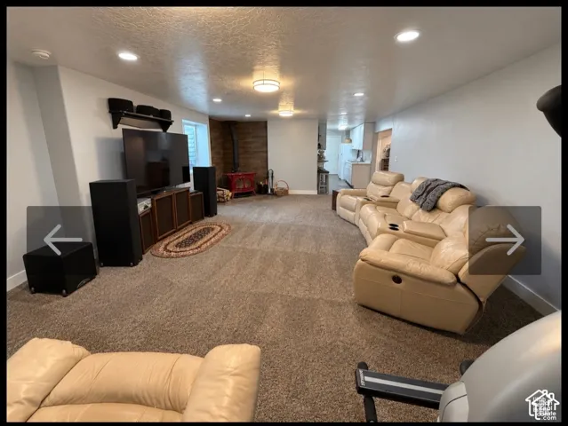 Open lower-level layout connecting the family room, wood stove and second kitchen,perfect for entertaining.