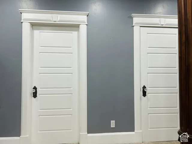 Five-panel doors with vintage-style crystal knobs, ornate backplates and custom keystoneheaders.