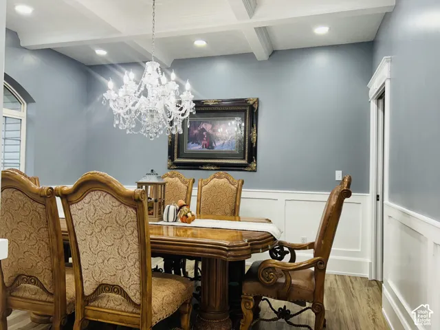 Formal dining room with a coffered ceiling, statement crystal chandelier and elegantwainscoting.