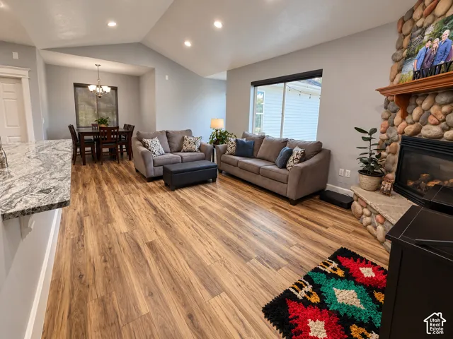 Family room with a vaulted ceiling and river rock fireplace, flowing into a casual diningarea.