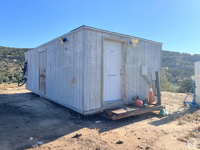 Portable storage unit with dual entry doors and wall-mounted solar lighting