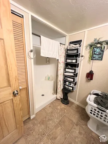 Corner shower stall with a white base and a privacy curtain
