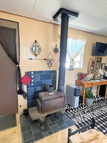 Cast iron wood-burning stove with a black tile hearth and a matching wall surround