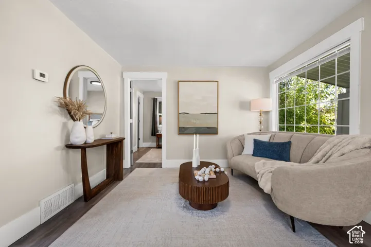 Wood-finish flooring, light-toned wall paint, crisp white trim, and a large multi-pane window