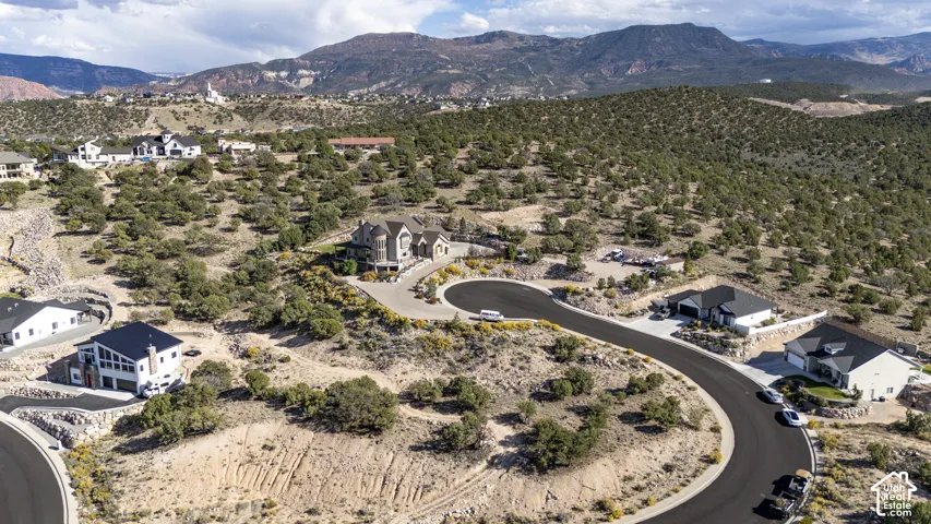 Paved roads traverse a natural, elevated landscape with scattered residential properties