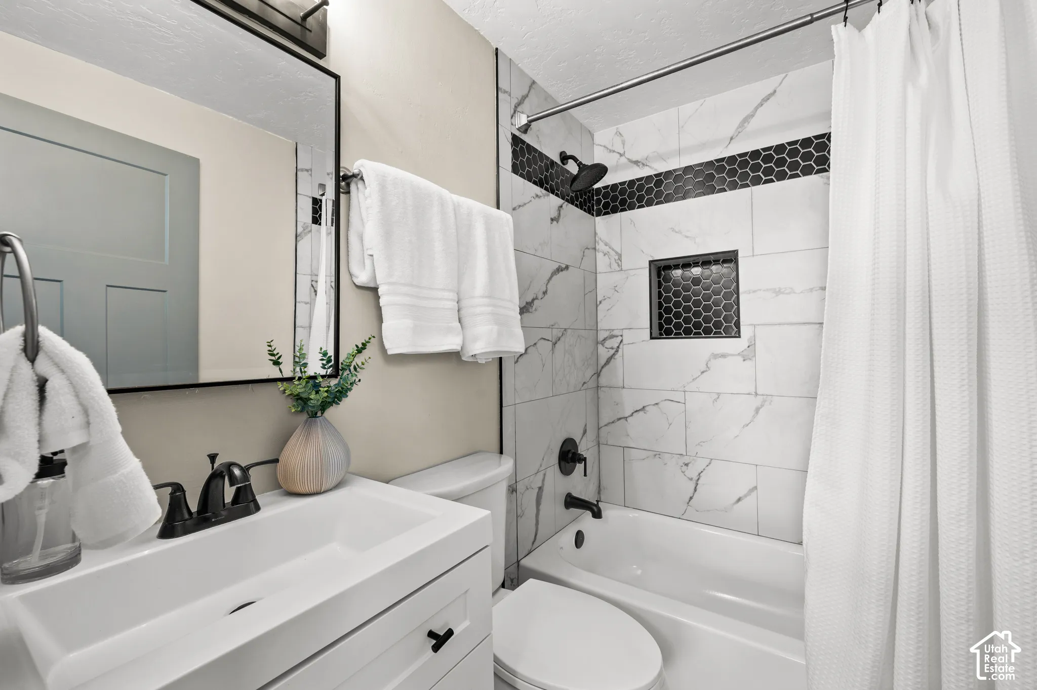 White vanity with integrated sink and matte black hardware