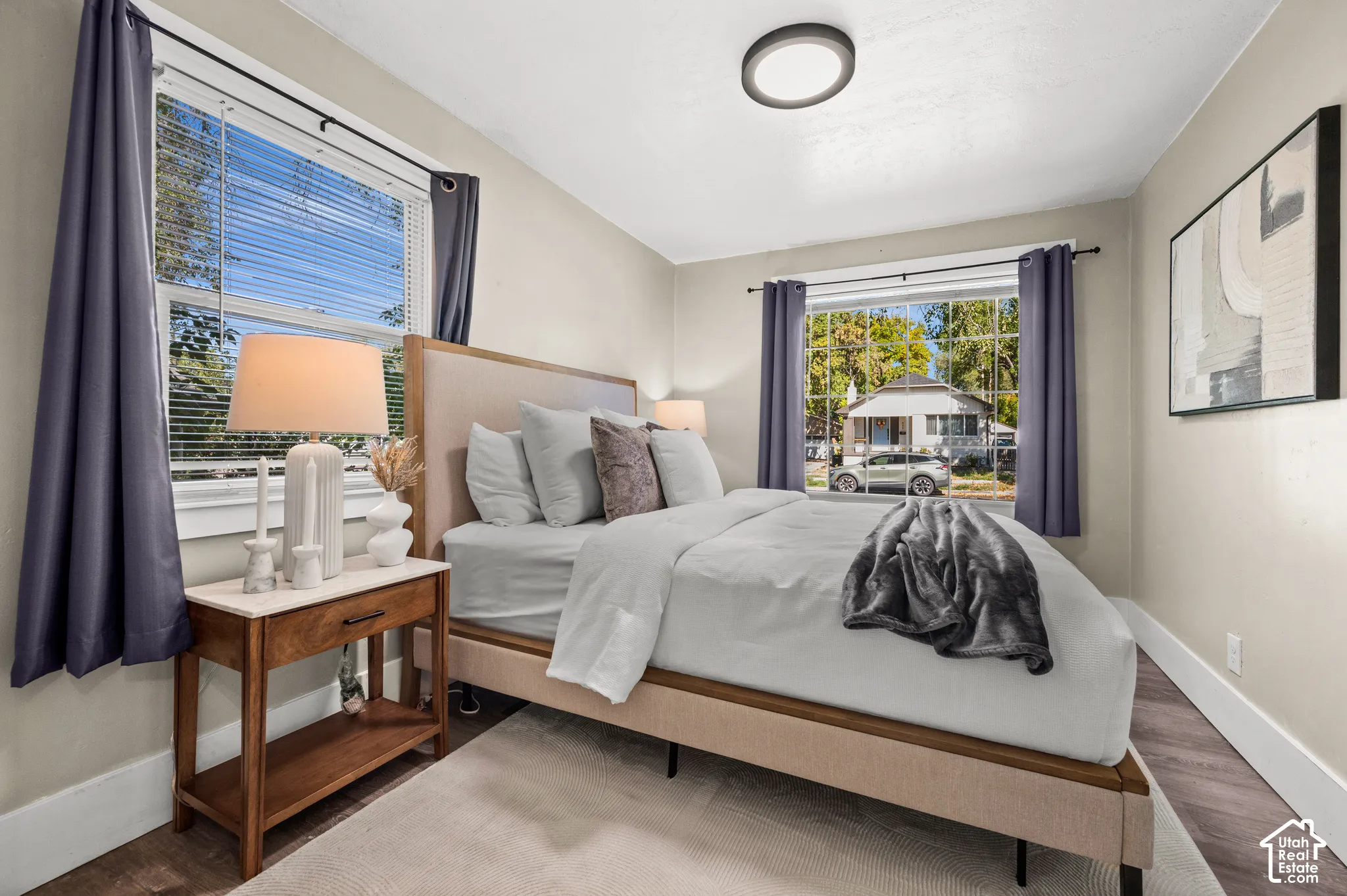 Hardwood-style flooring, white baseboards, and window blinds